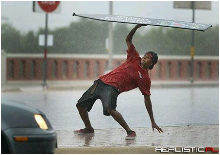 Guy spinning a business sign in the rain